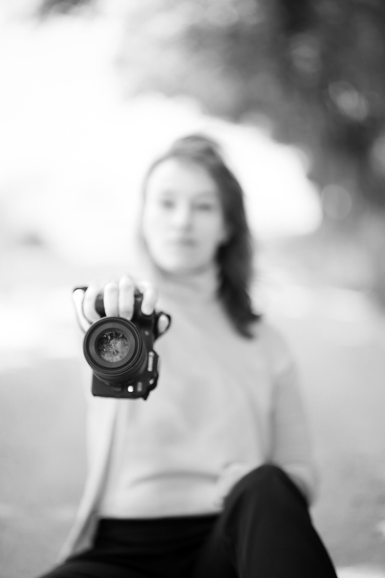 Fotograf Hamburg Eimsbüttel, Eppendorf, Hafencity, Bergedorf, Wandsbek, Barmbel, Fotografin im Feld mit Kamera in der Hand, Bild unscharf, Fokus auf Kamera