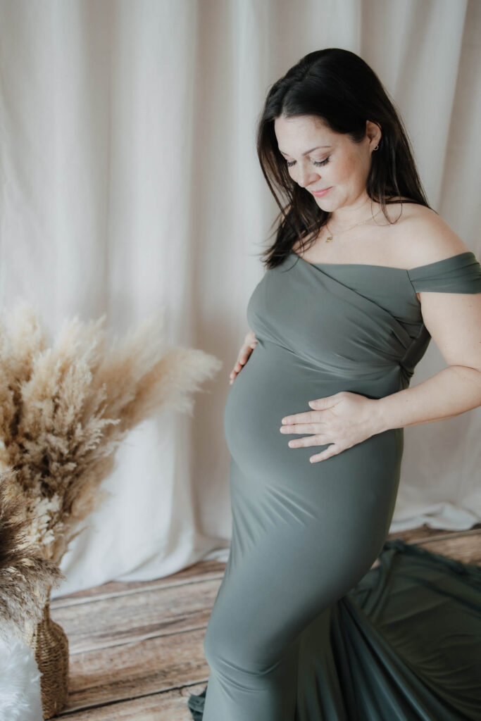 Babybauchfotos Hamburg, Schwangere trägt eoin grünes Kleid vor einer Boho Kulisse, Hamburg, Escheburg