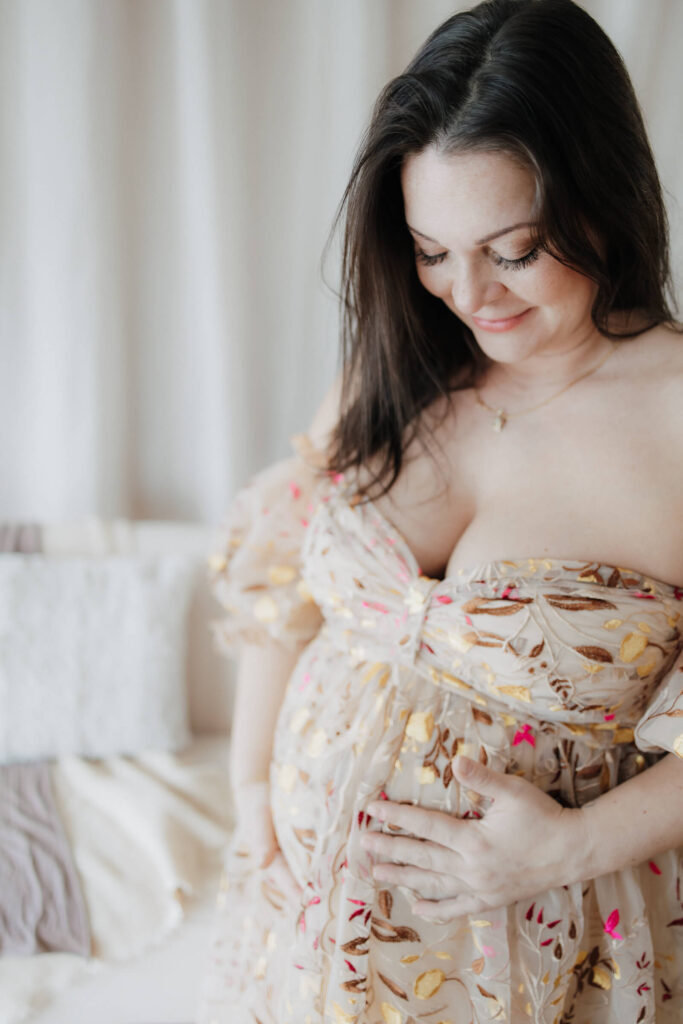 Babybauchfotos Hamburg, Schwangere trägt ein florales Tüll-Kleid vor einer Boho Kulisse, Hamburg, Escheburg